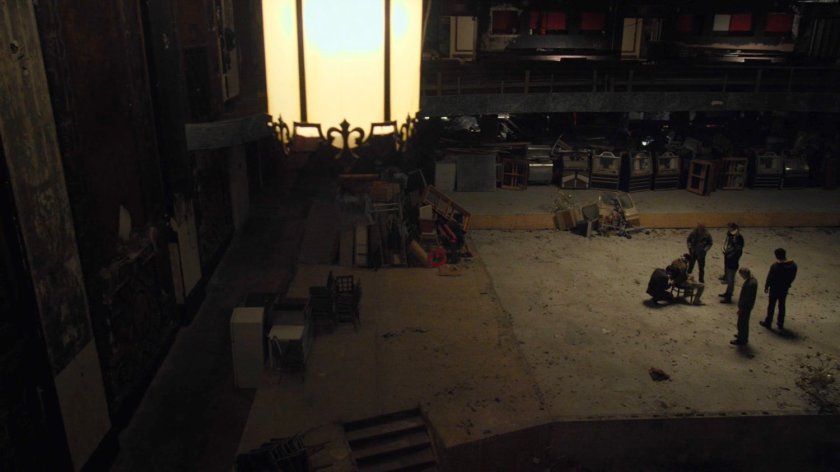 The Defenders surround a captured Sowande in a derelict theater.