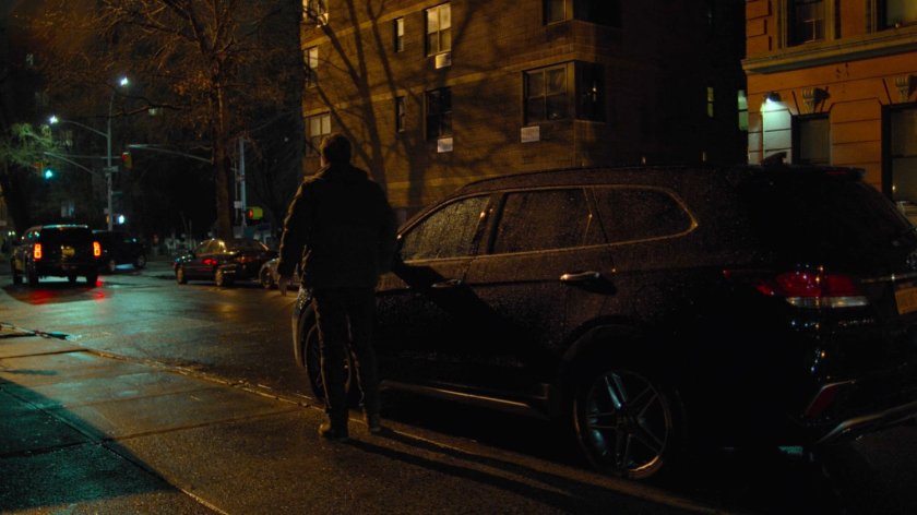 Danny standing by his car in front of Claire Temple's apartment building.