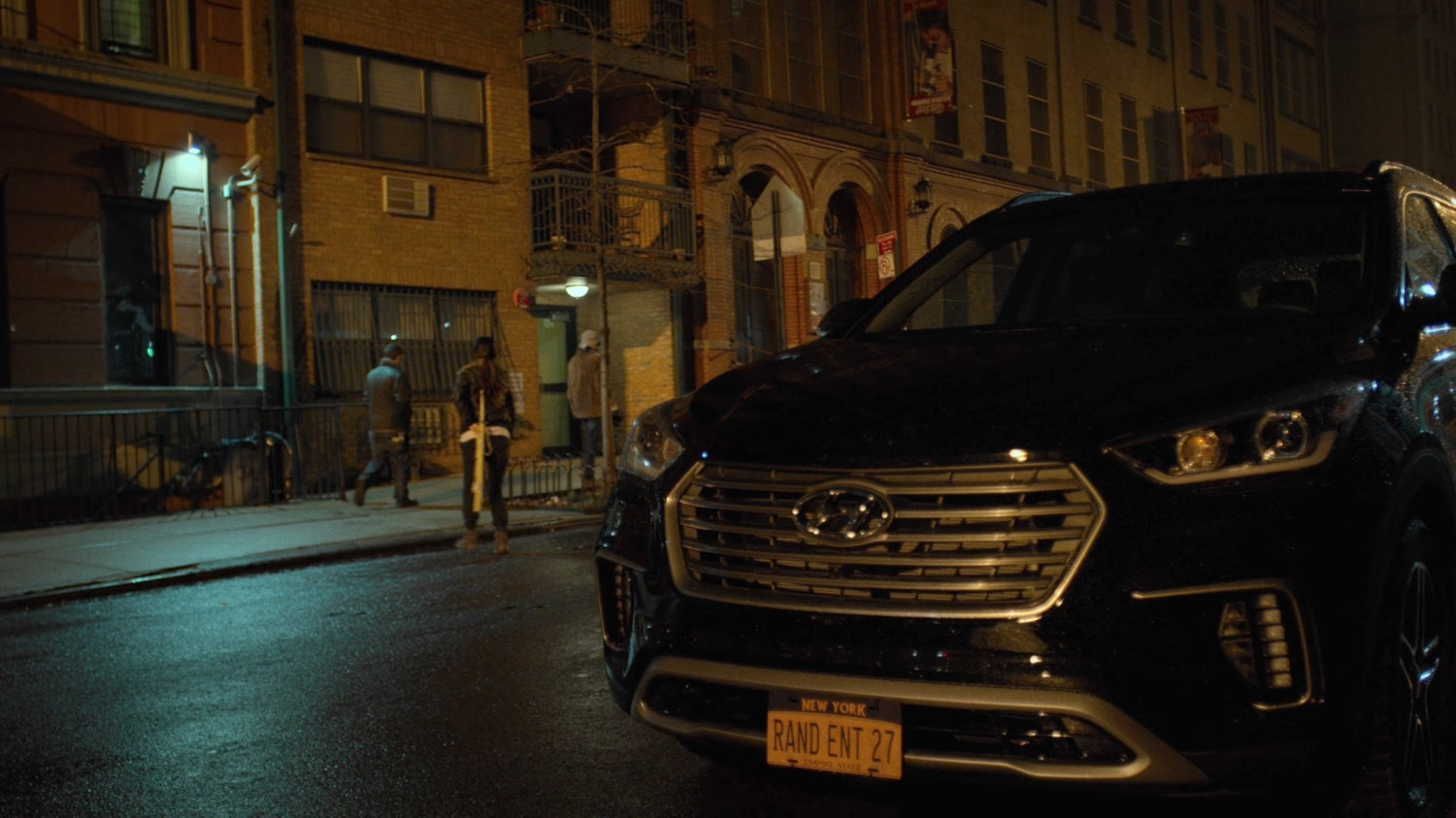 Colleen runs across street in front of Claire Temple's apartment building.