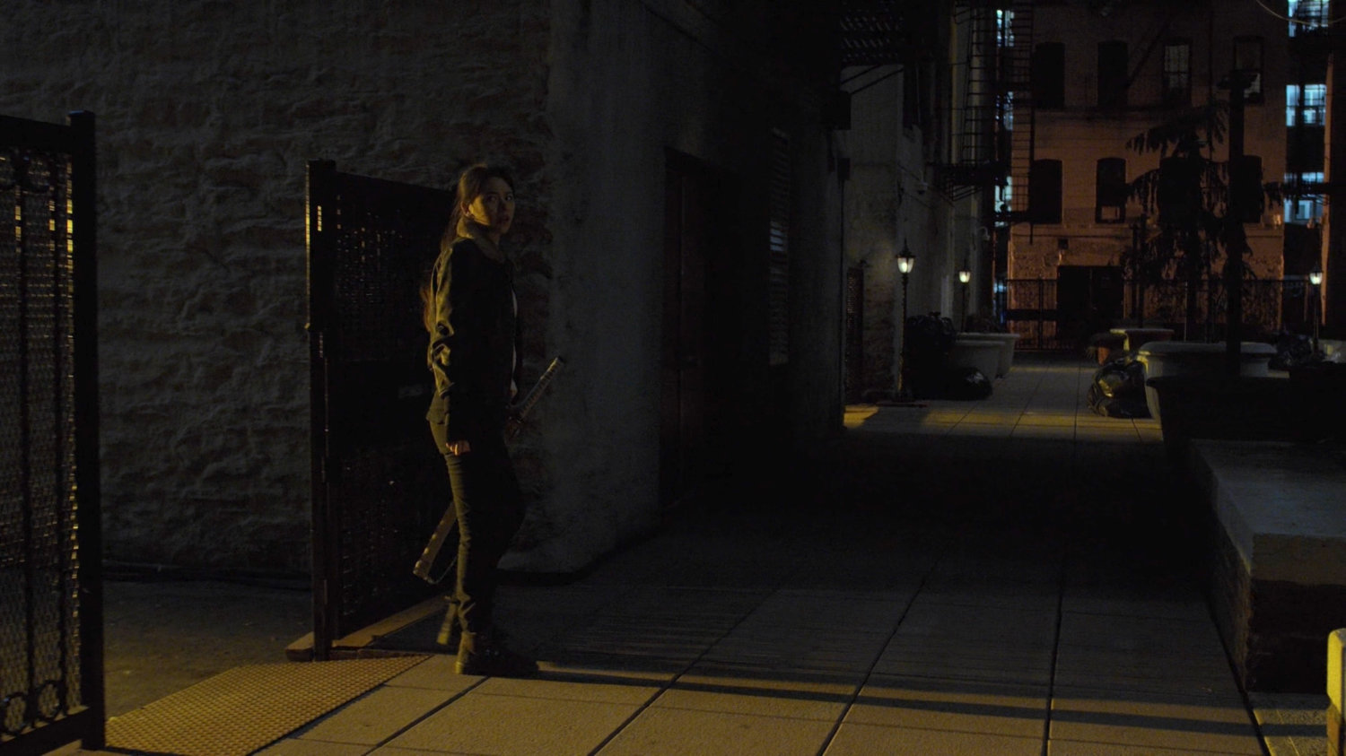 Colleen enters a wide alley.