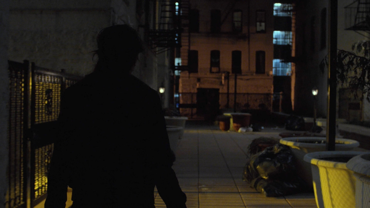 Colleen enters a wide alley.