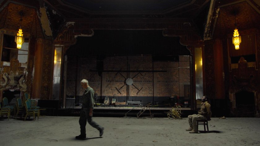 Stick walks away from a captured Sowande in a derelict theater.