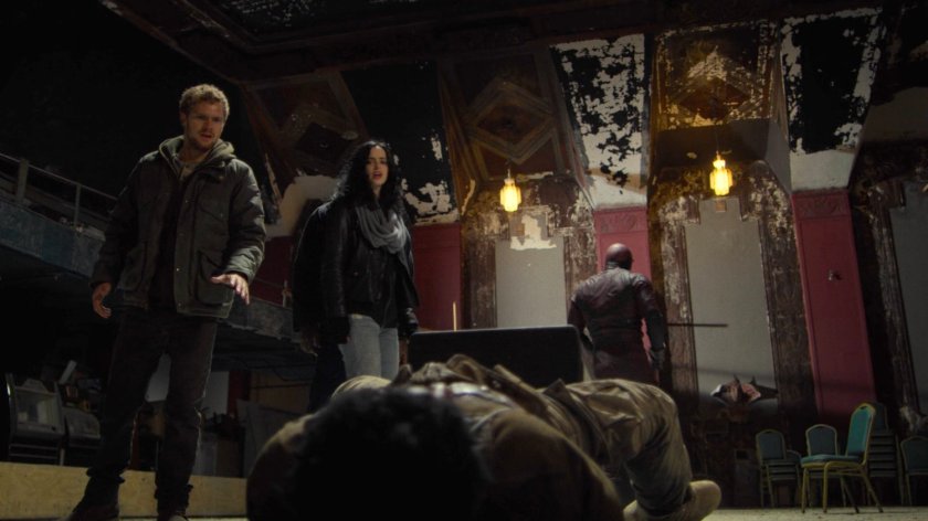 Danny and Jessica stand over an unconscious Sowande in a derelict theater.