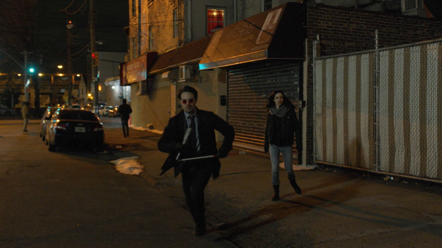 Matt and Jessica run towards a dilapidated theater.