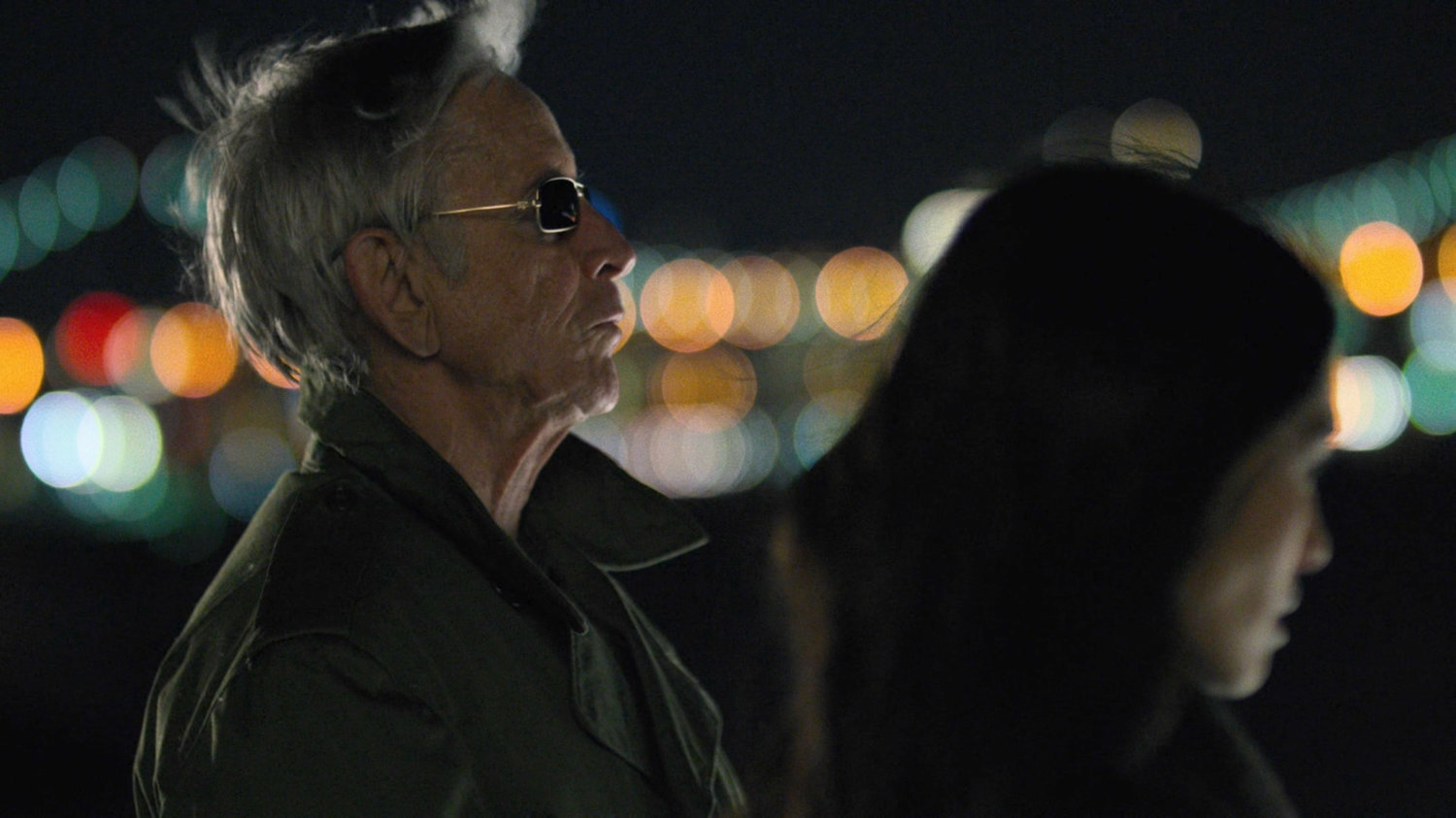 Stick and Elektra in a parking lot at night.