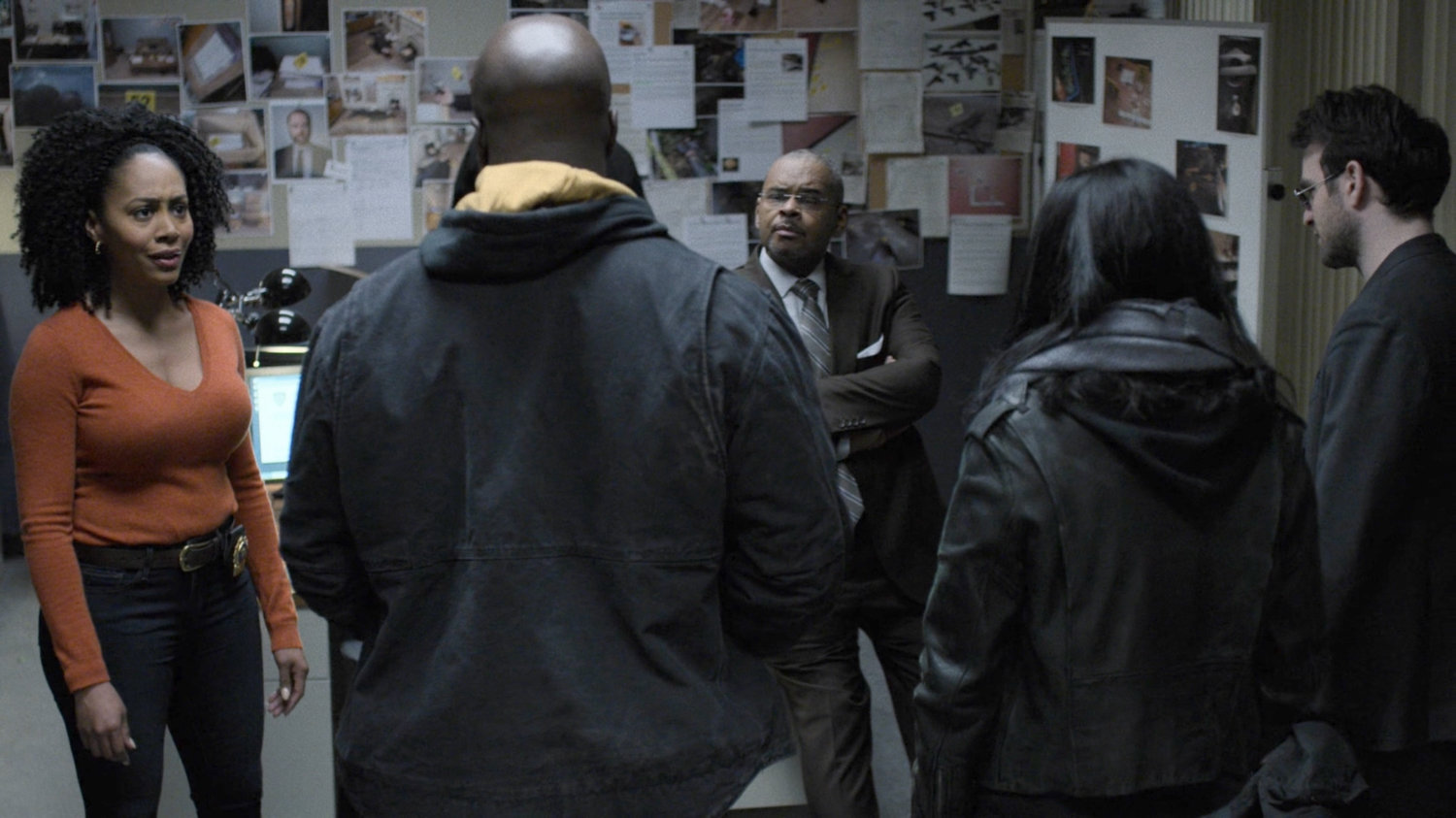 Misty and Strieber talk with Luke, Jessica, and Matt in an office at the 29th Precinct.