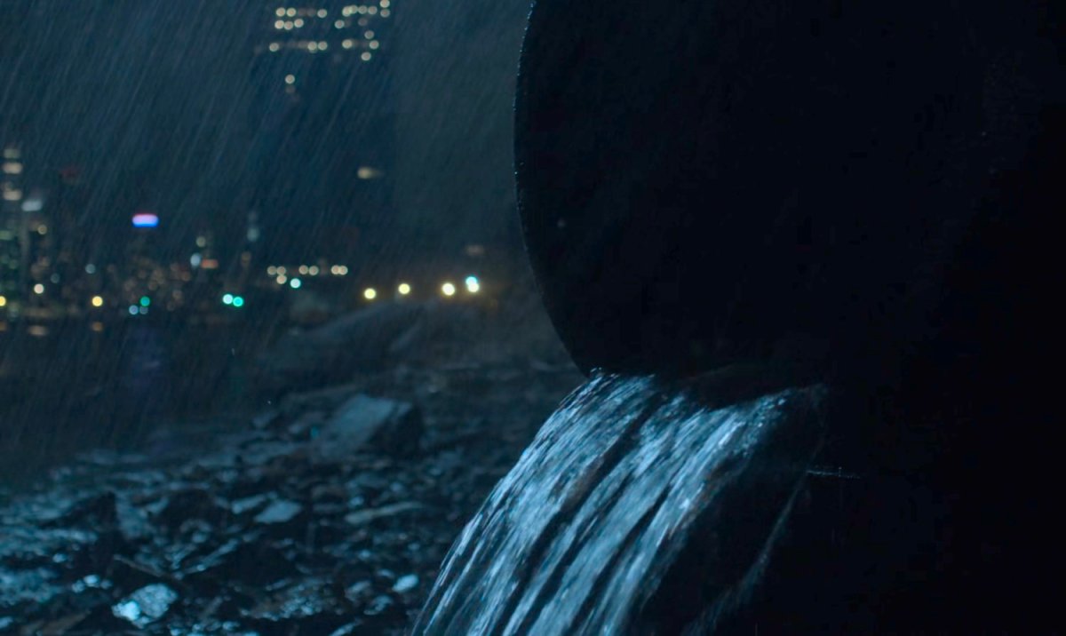 A sewer pipe emptying on a rainy night.