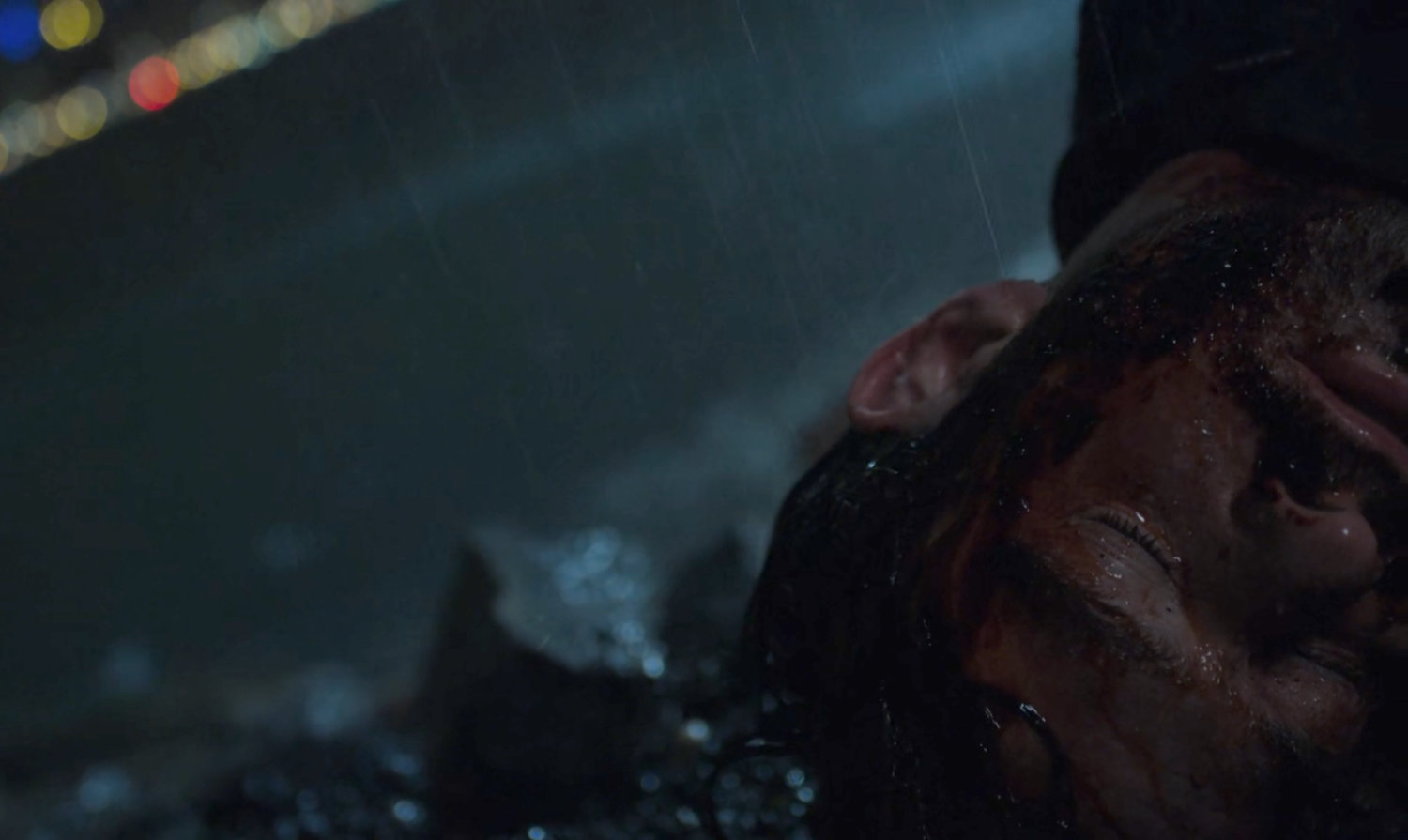 Matt Murdock on the edge of a river at night in the rain.