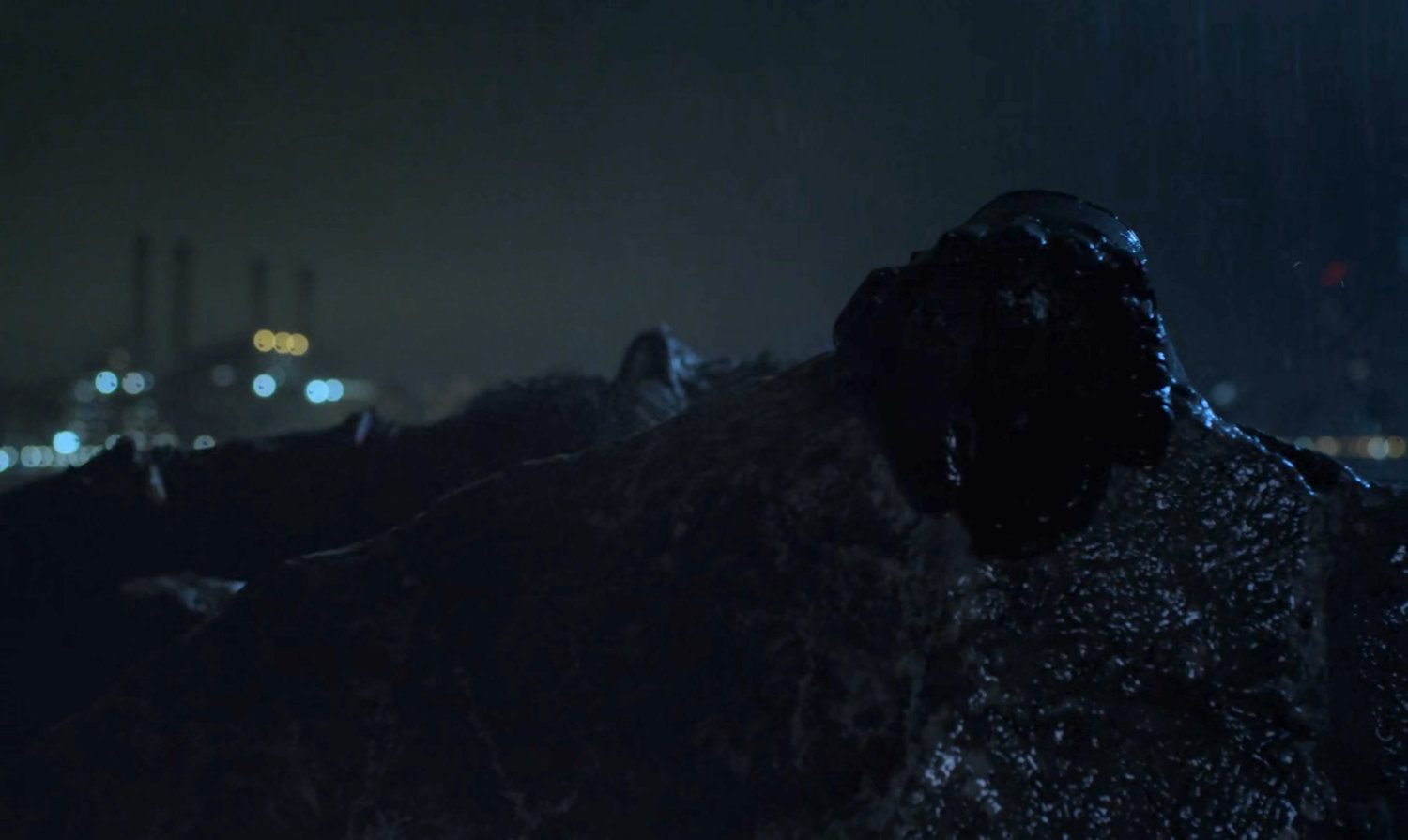Matt Murdock's hand on a rainy rock at night.