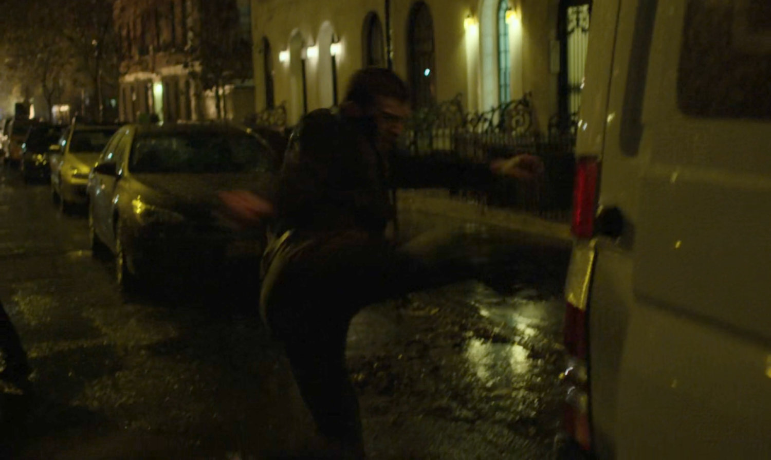 The Man in Black fights kidnapper on a dark street.
