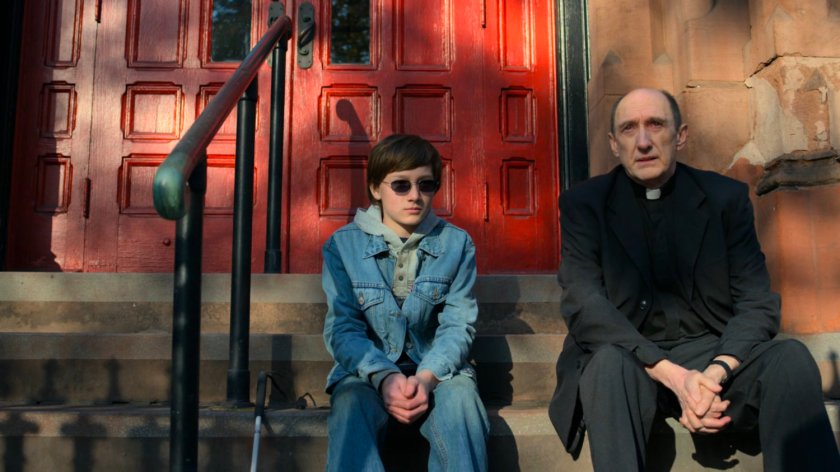 Young Matt speaks with Father Lantom outside the church.