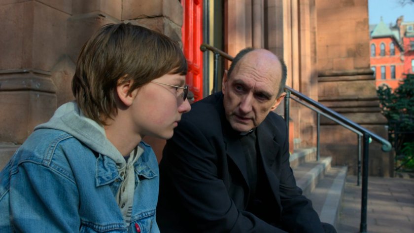 Young Matt speaks with Father Lantom outside the church.