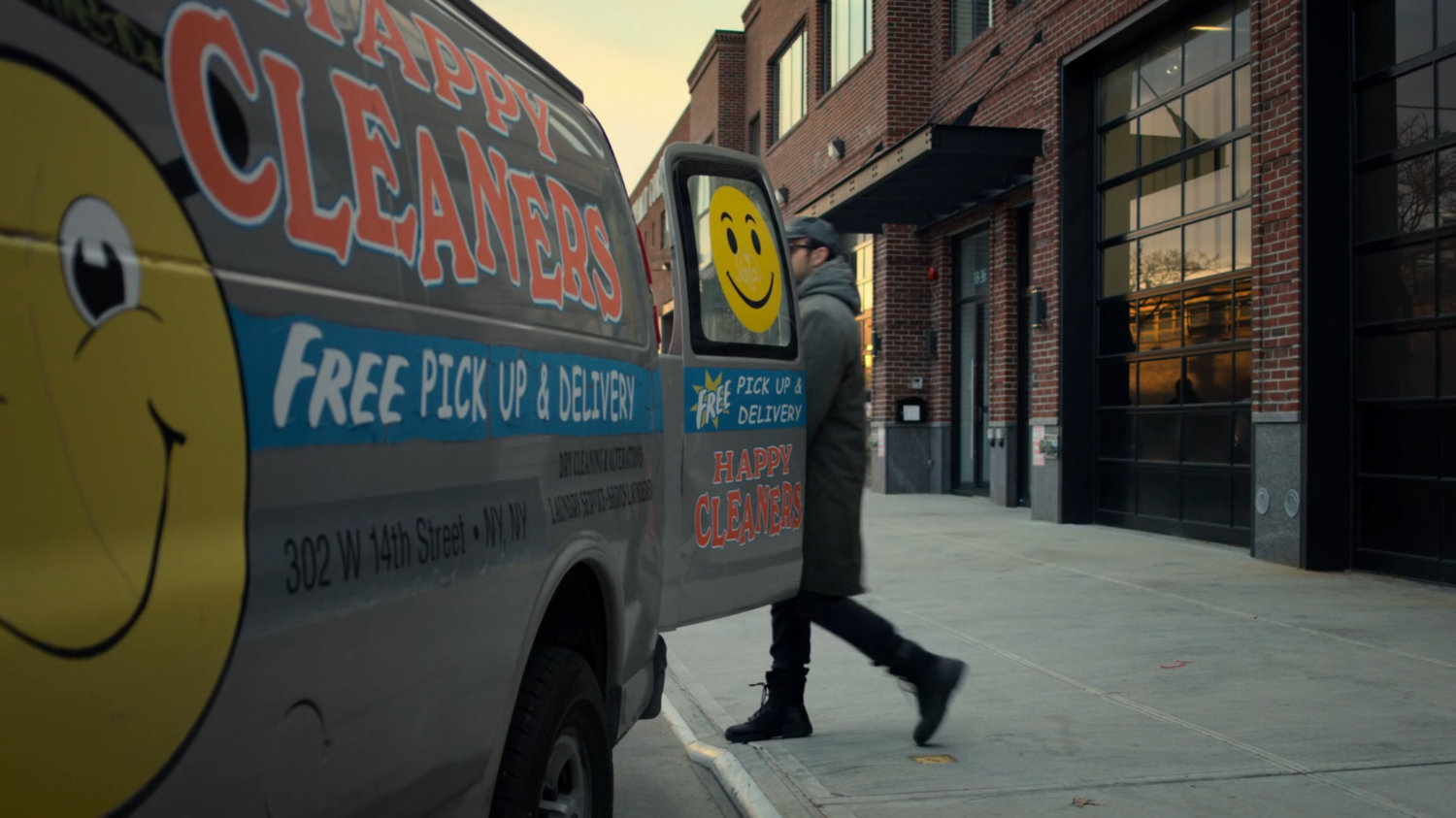 Matt walking past Happy Cleaners van parked by sidewalk.