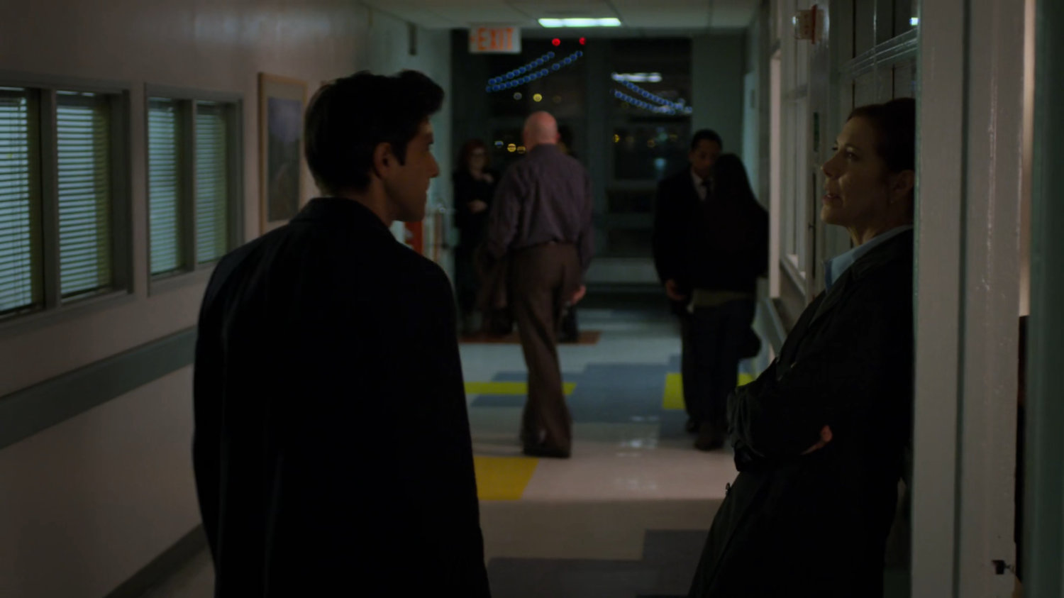 Nadeem speaks with SAC Hattley in the hallway of the hospital.