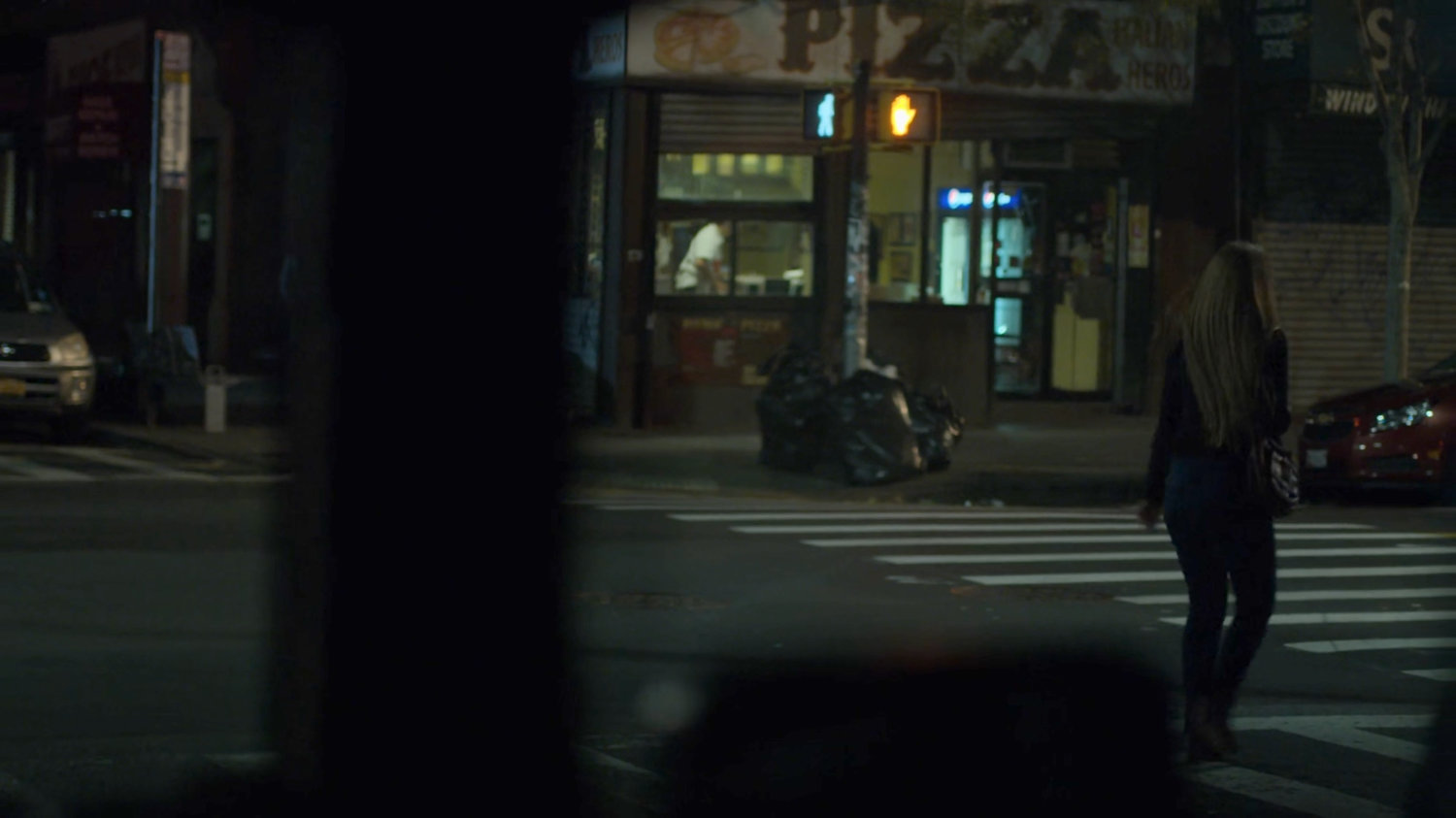 Dex spying on Julie crossing a street towards a pizza parlor.