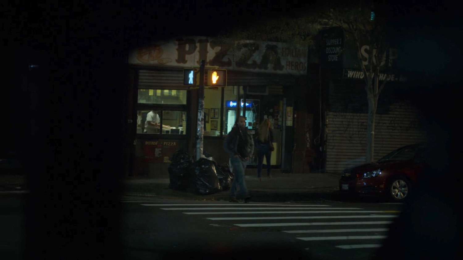 Dex spying on Julie entering a pizza parlor.