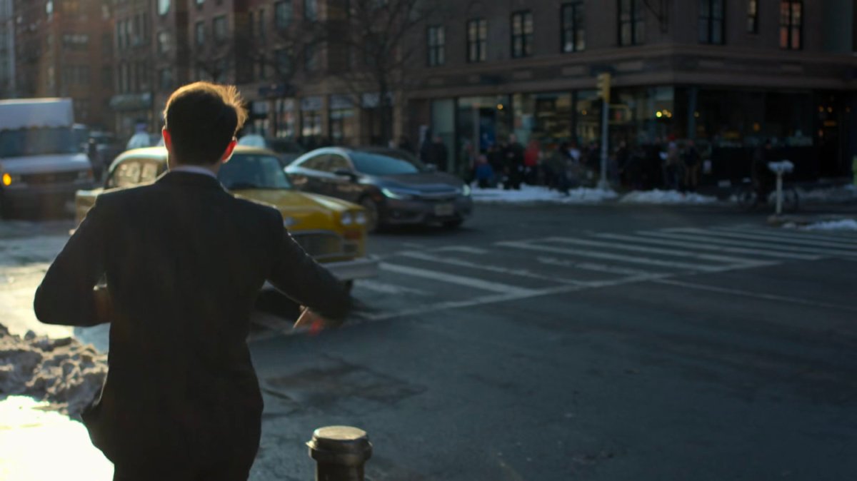 Matt stepping off curb towards taxi.