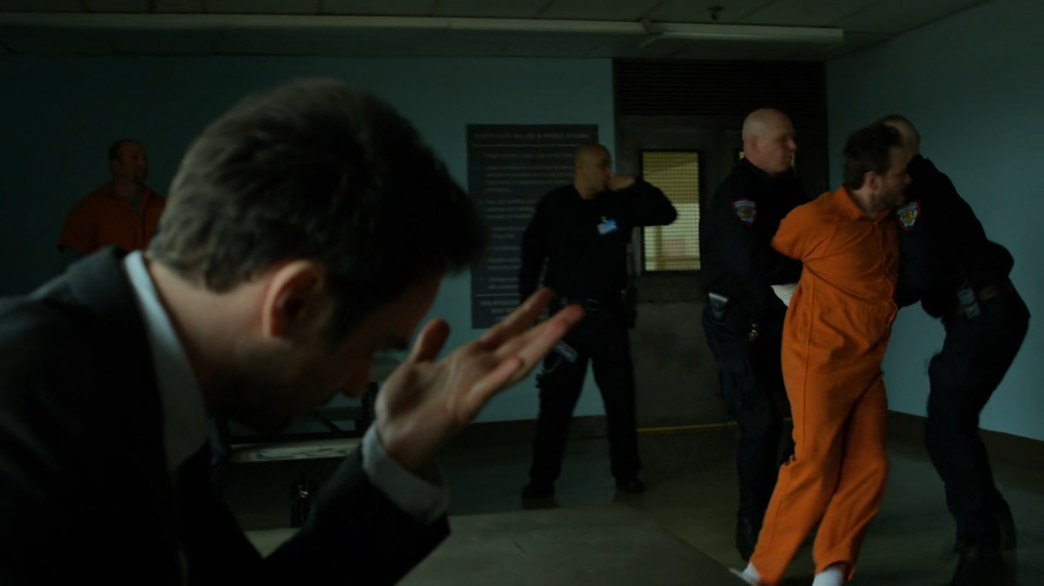 Michael being restrained by guards in the penitentiary visitor room.
