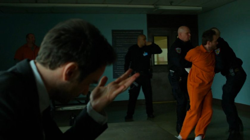 Michael being restrained by guards in the penitentiary visitor room.