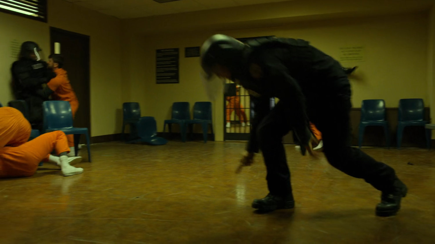Fighting prisoners and guards in penitentiary rec room.