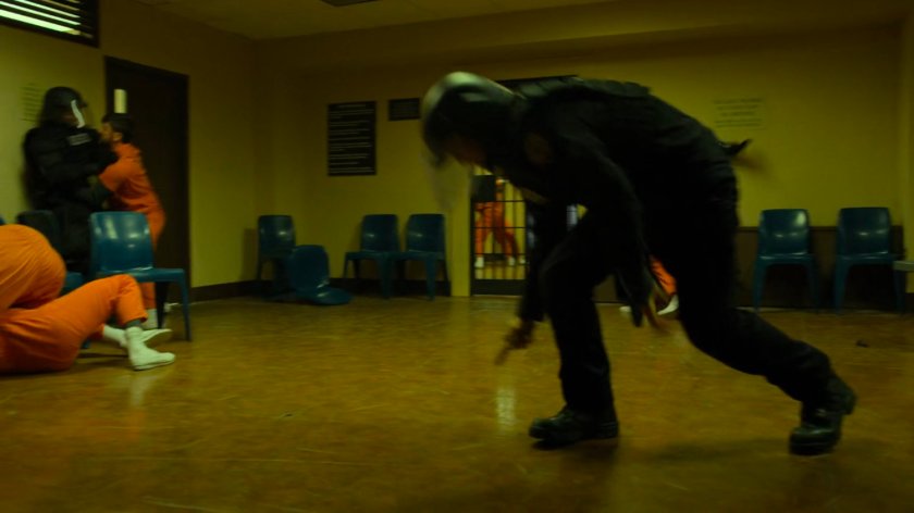 Fighting prisoners and guards in penitentiary rec room.