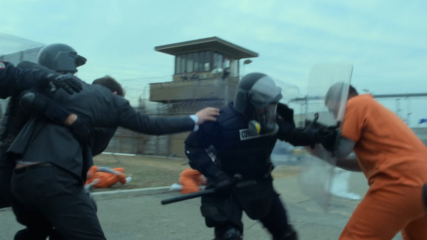 Guards lead Matt past rioting inmates at penitentiary.