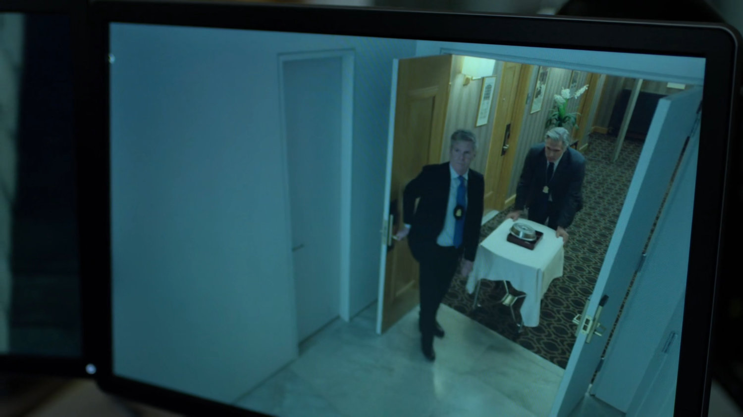 Two FBI agents wheel a trolley of food into the penthouse of the Presidential Hotel.