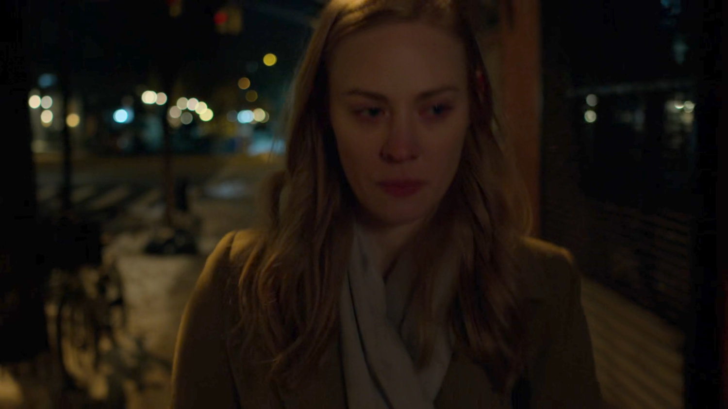 Karen walks along a dark sidewalk at night.