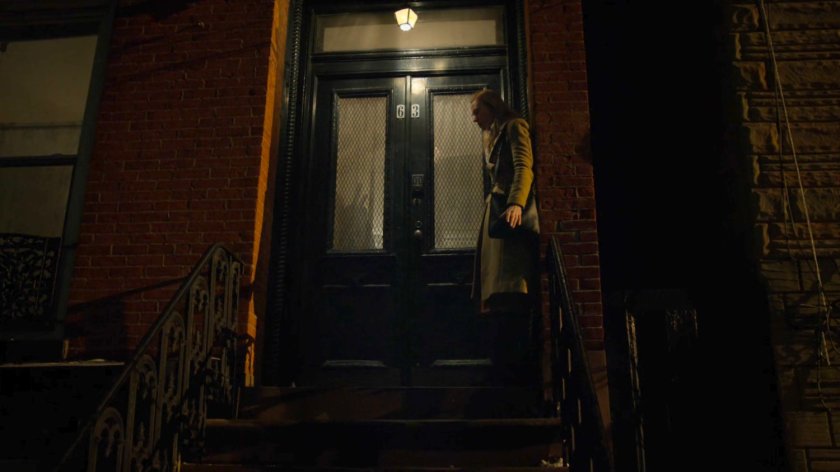 Karen on the front steps of Tanya Mills' building at night.