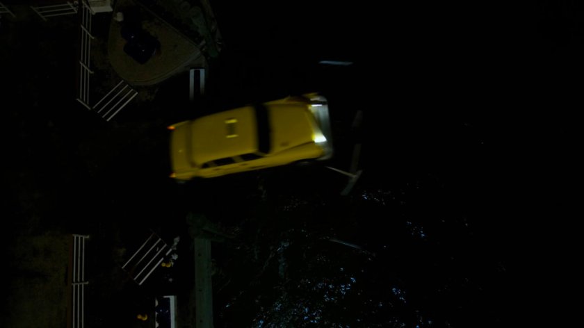 Aerial view of cab breaking through pier railing and crashing into water.