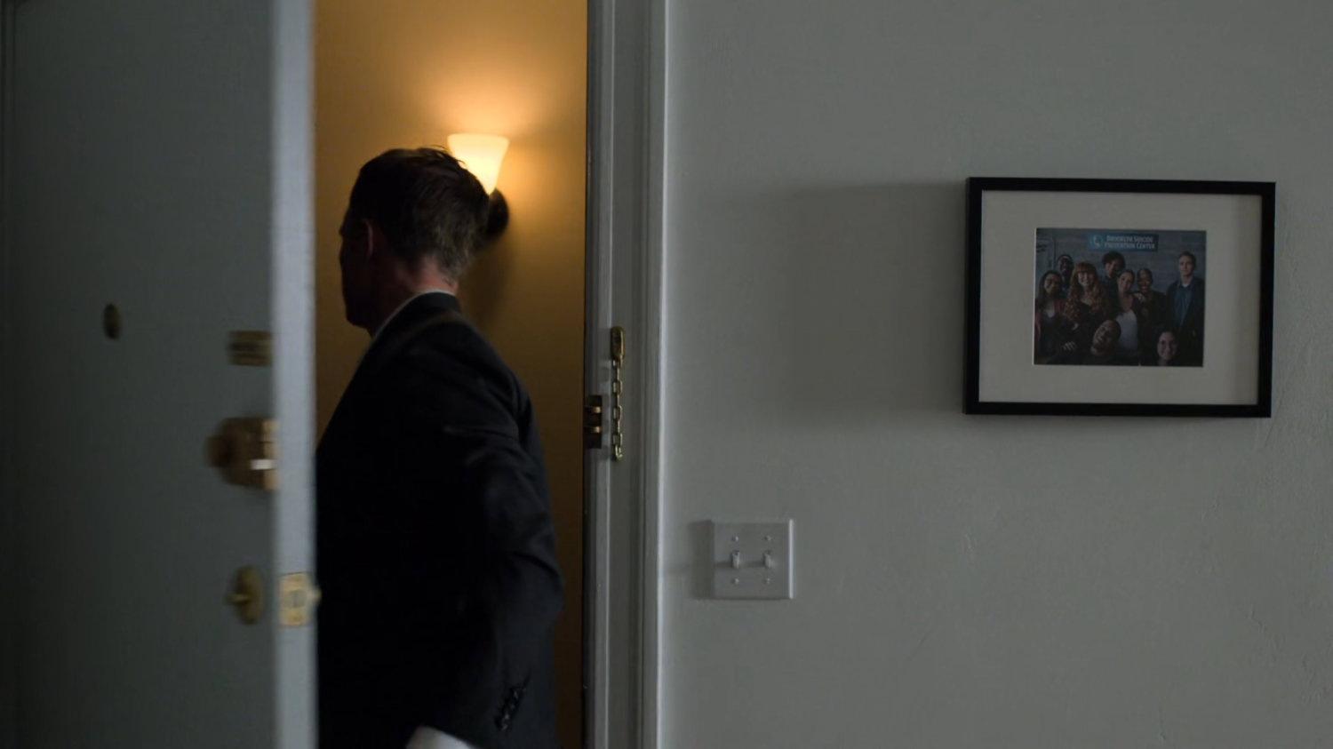 Dex exiting through the front door of his apartment.