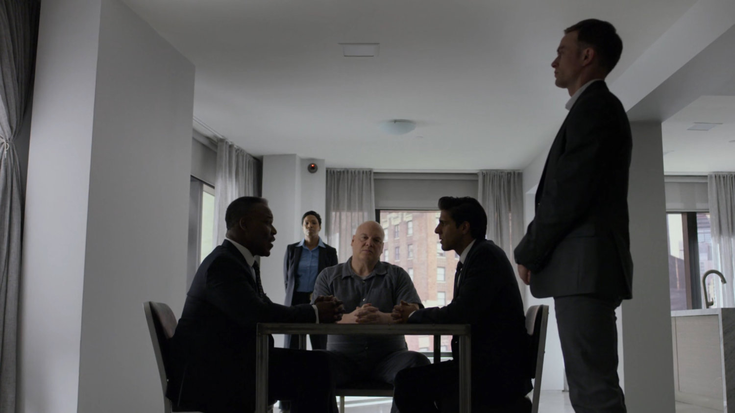 Fisk and Donovan meeting with FBI agent Nadeem in the penthouse of the Presidential Hotel, while Dex looks on.