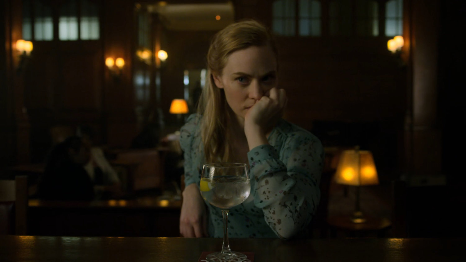 Karen sits at a bar in a social club.