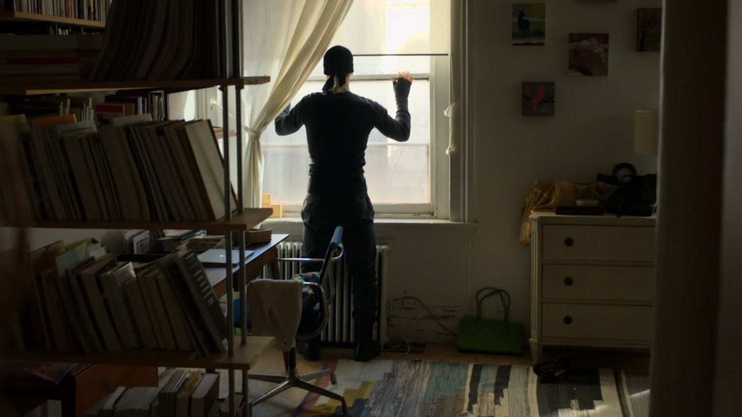 Matt standing by window in Karen's apartment.