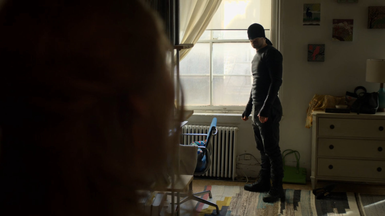 Matt standing by window in Karen's apartment.