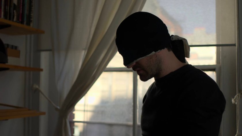 Matt standing by window in Karen's apartment.