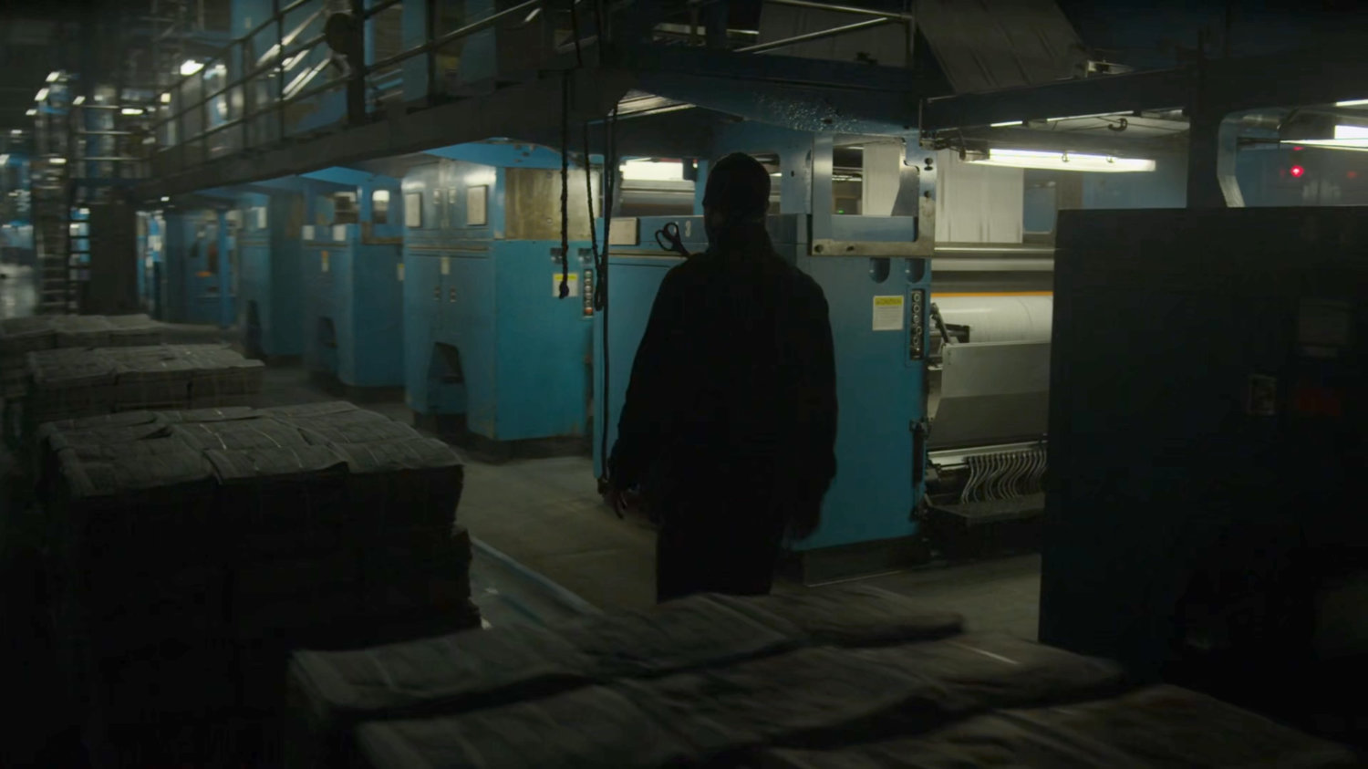 Matt walks through the printing press area of the New York Bulletin.