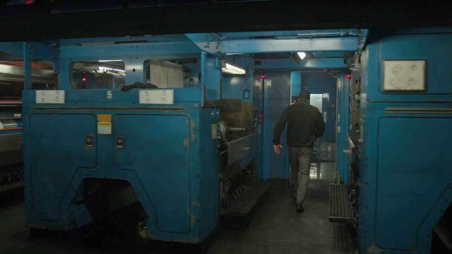 Matt walks through the printing press area of the New York Bulletin.