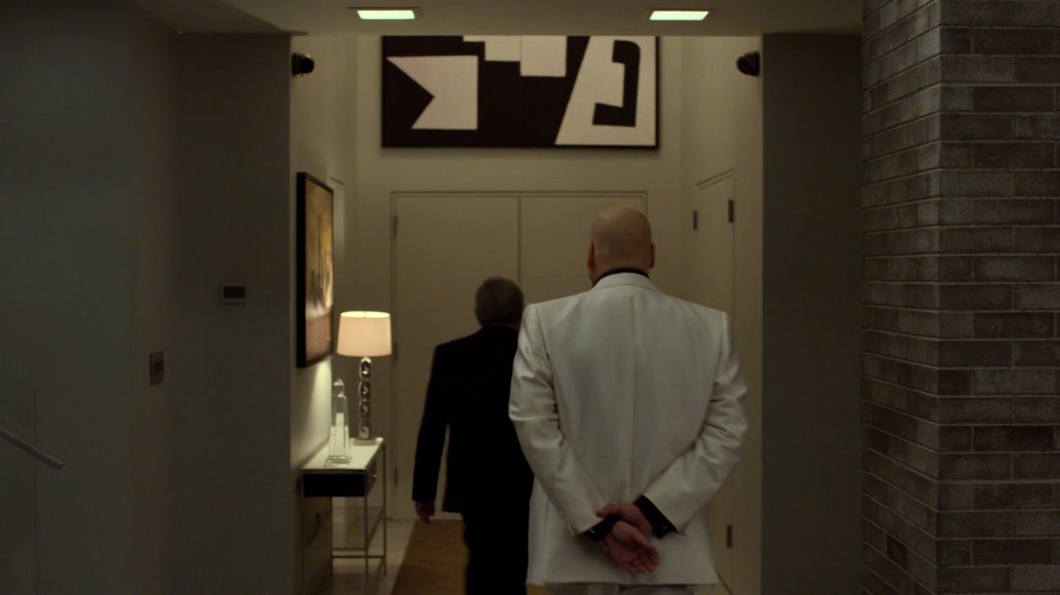 Disk and Lee walk towards front door of the penthouse of the Presidential Hotel.