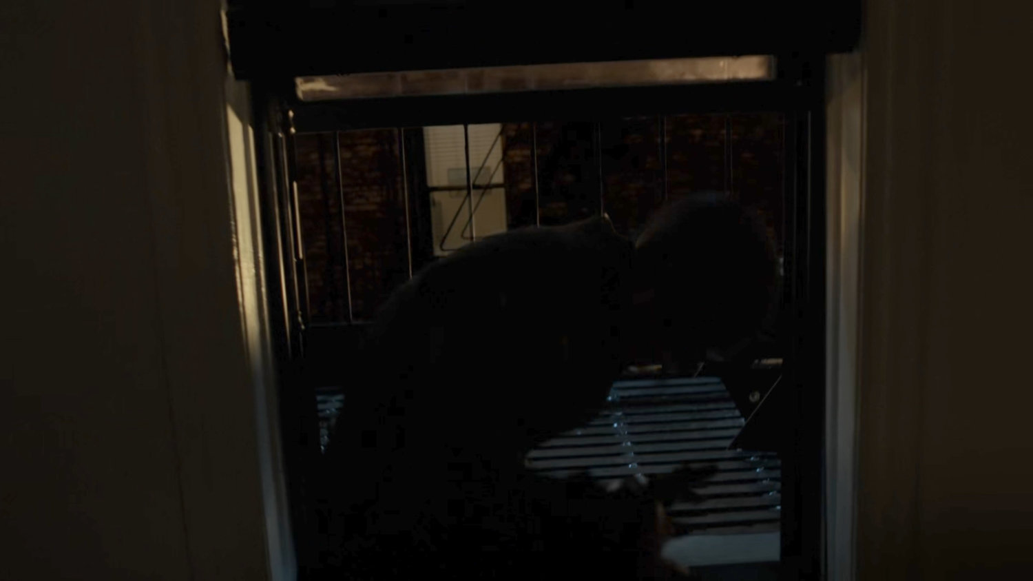 Dex dressed as daredevil climbing in his apartment window.