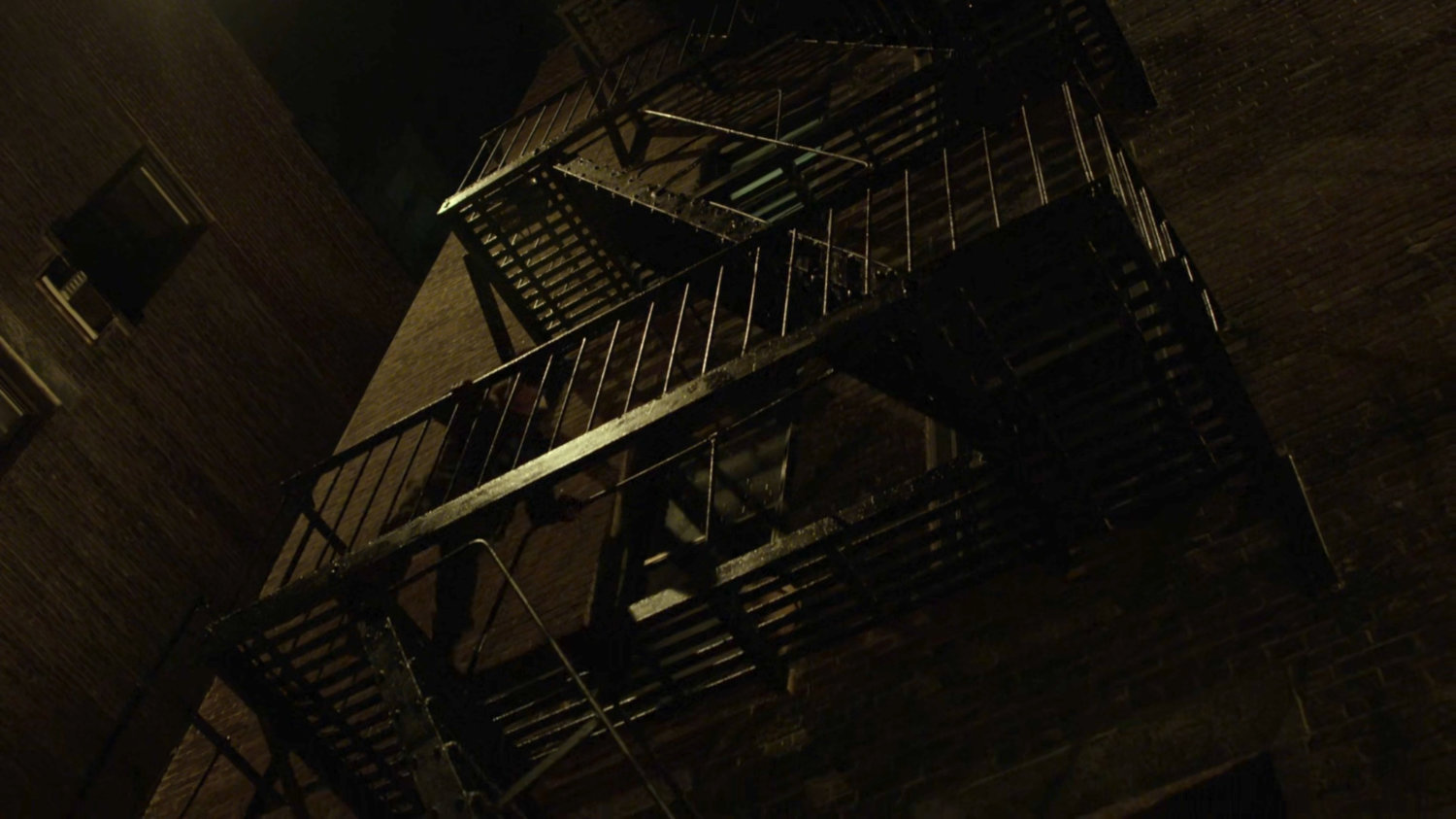 Matt climbing down the fire escape of Dex's apartment.