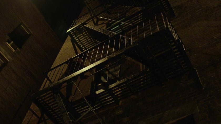 Matt climbing down the fire escape of Dex's apartment.