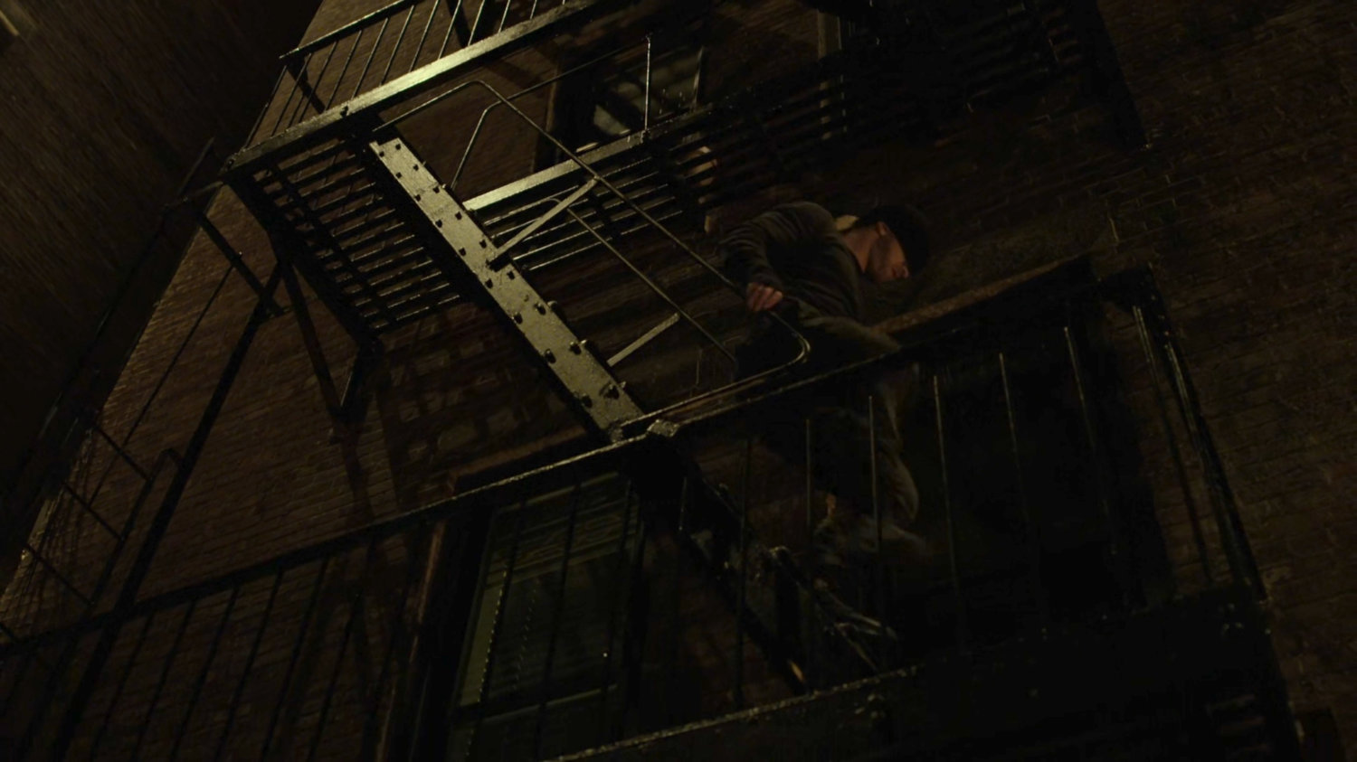 Matt climbing down the fire escape of Dex's apartment.