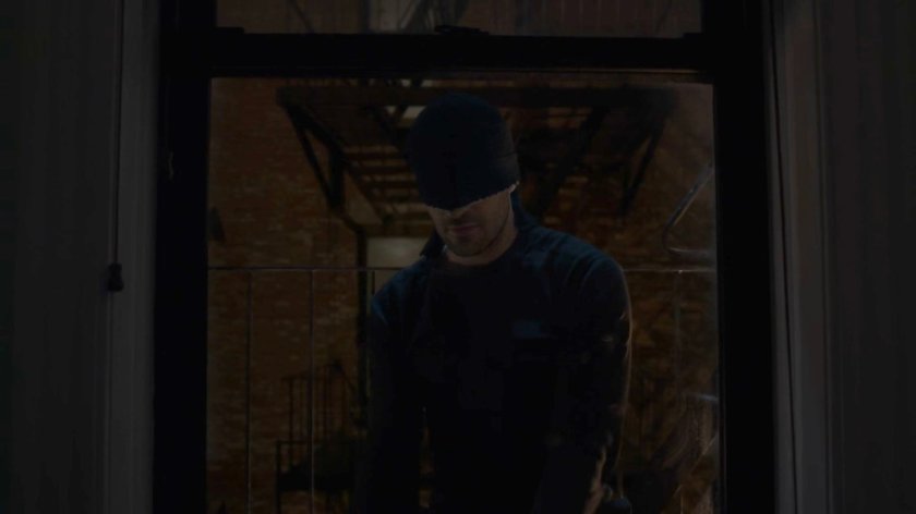 Matt climbing in the window of Dex's apartment.