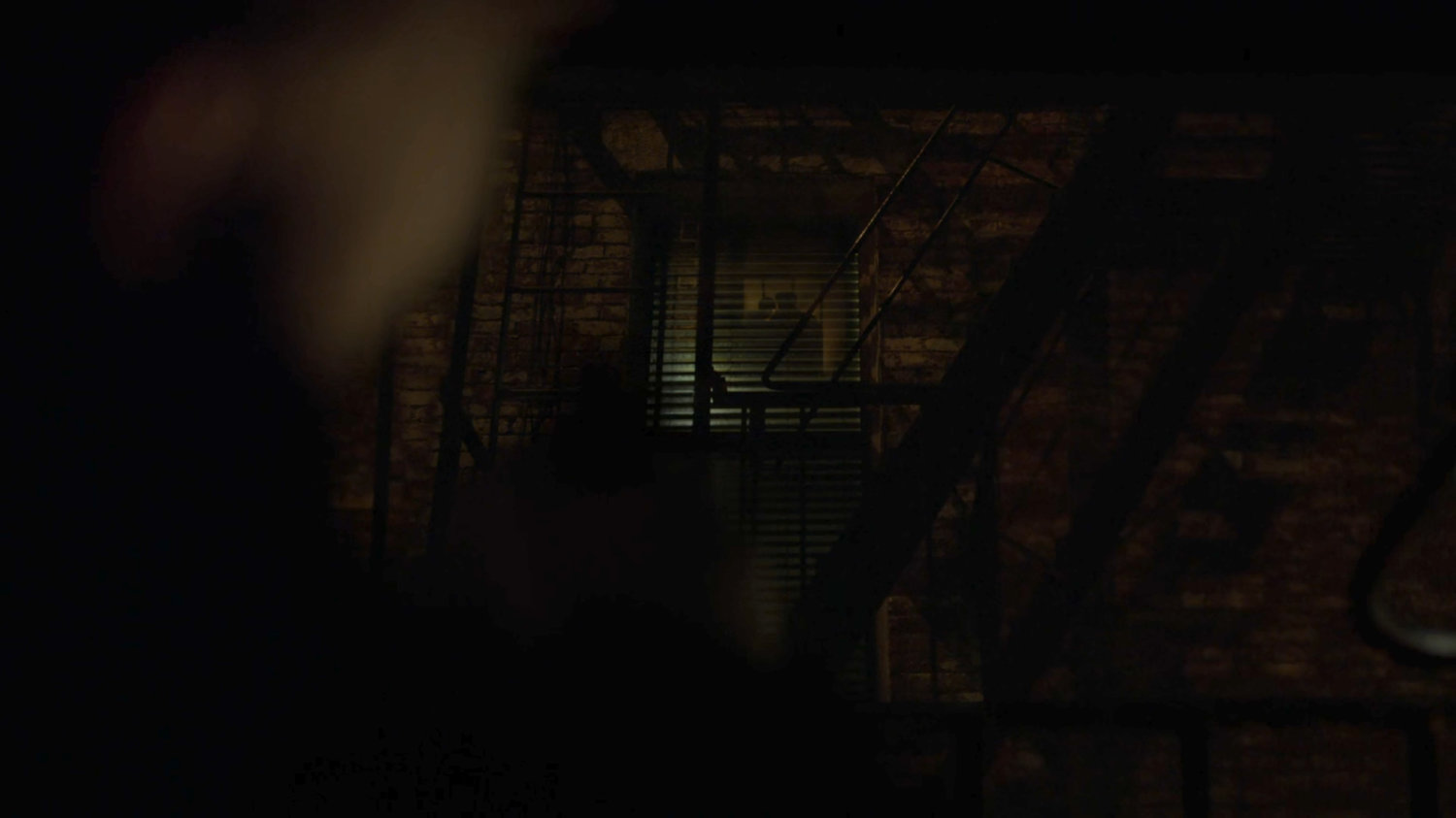 Dex watching the apartment across the alley.