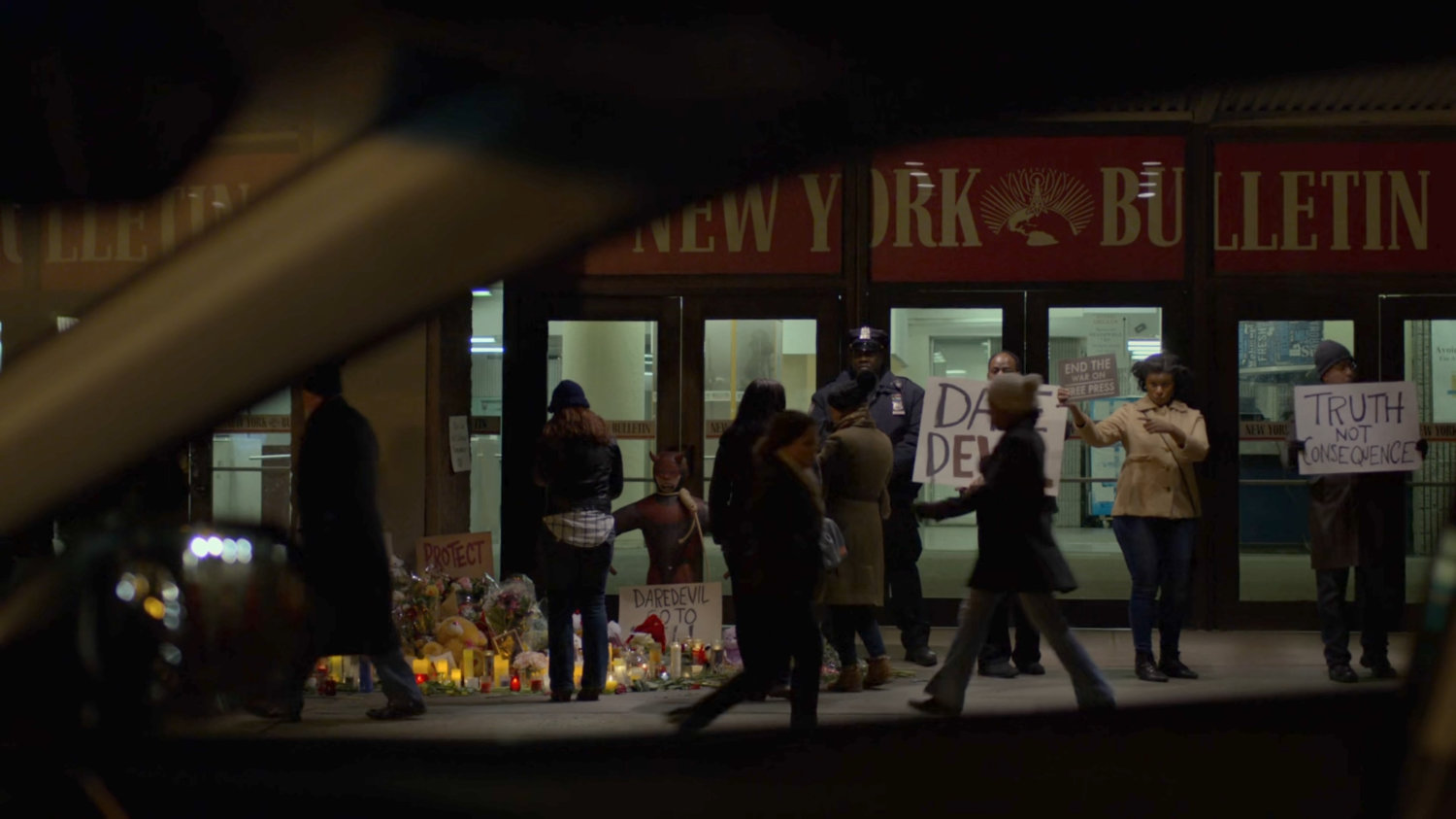 Karen's POV of protesters outside the New York Bulletin.