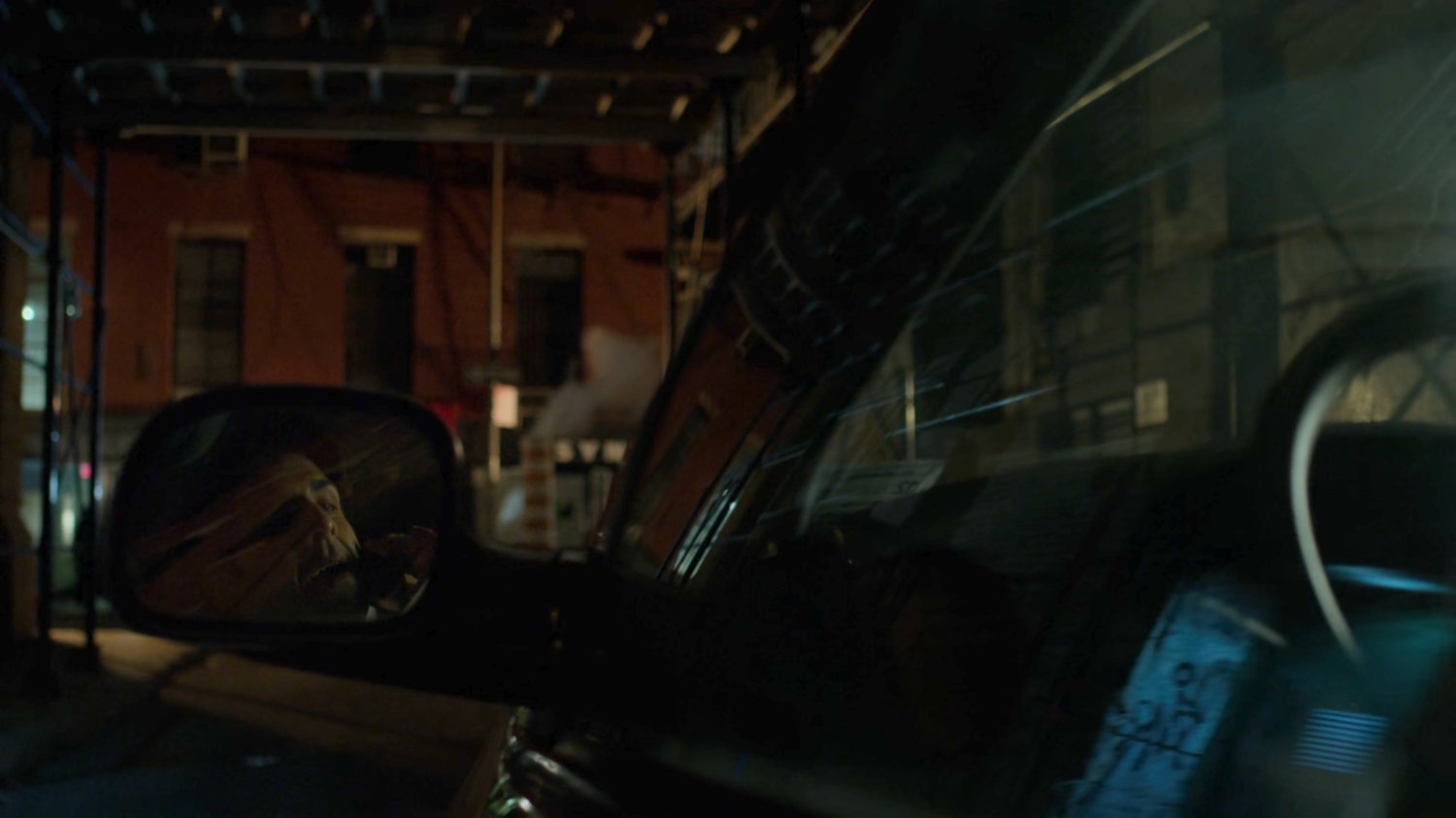 Ray Nadeem reflected in side mirror of his minivan in a dark alley.
