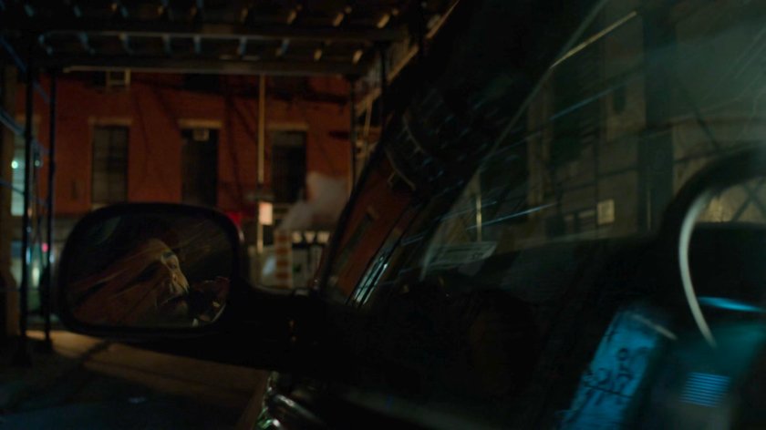 Ray Nadeem reflected in side mirror of his minivan in a dark alley.