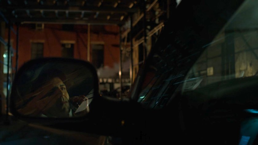 Ray Nadeem reflected in side mirror of his minivan in a dark alley.