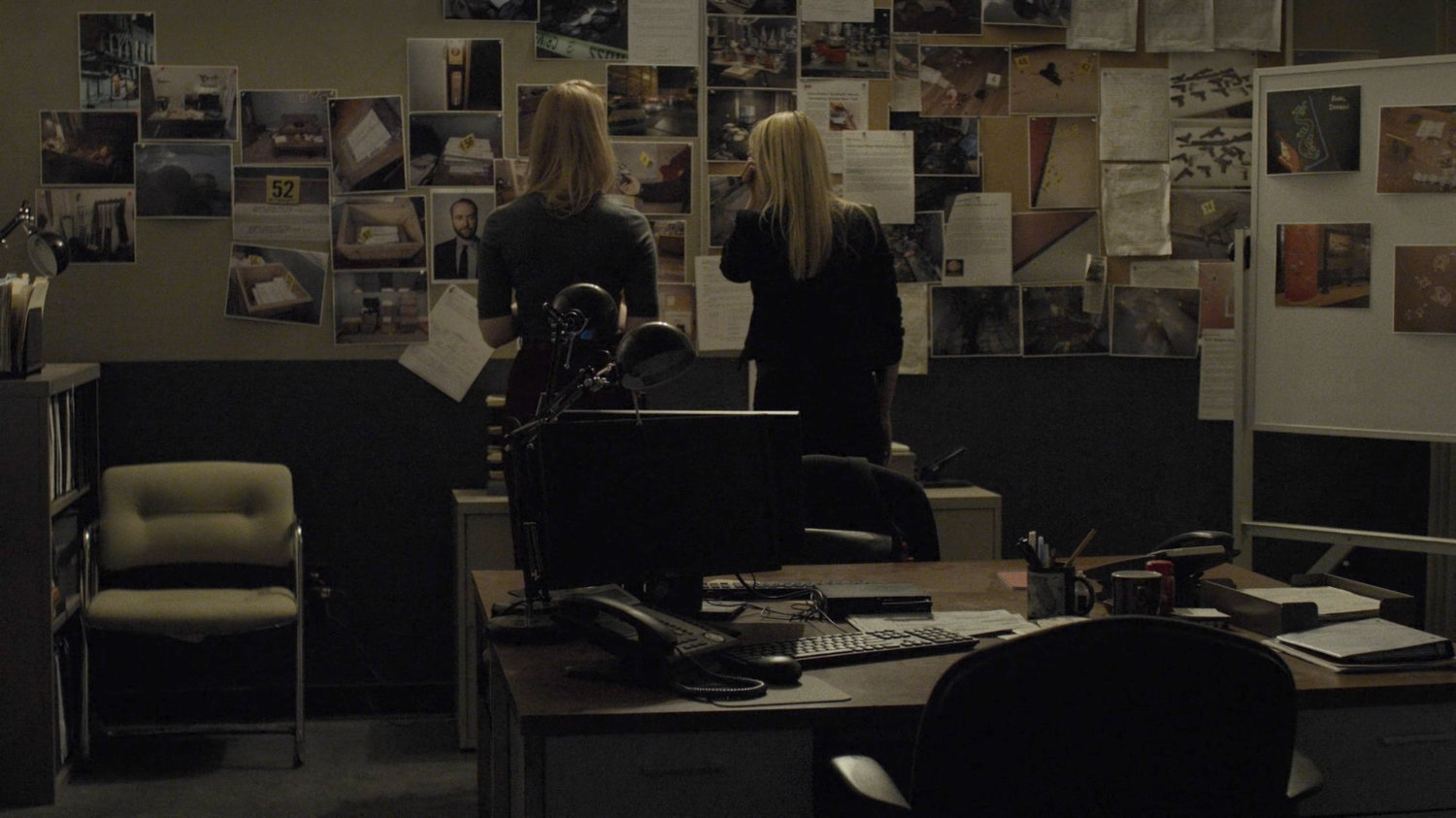 Karen and Trish look at a wall of photos in the 29th precinct.